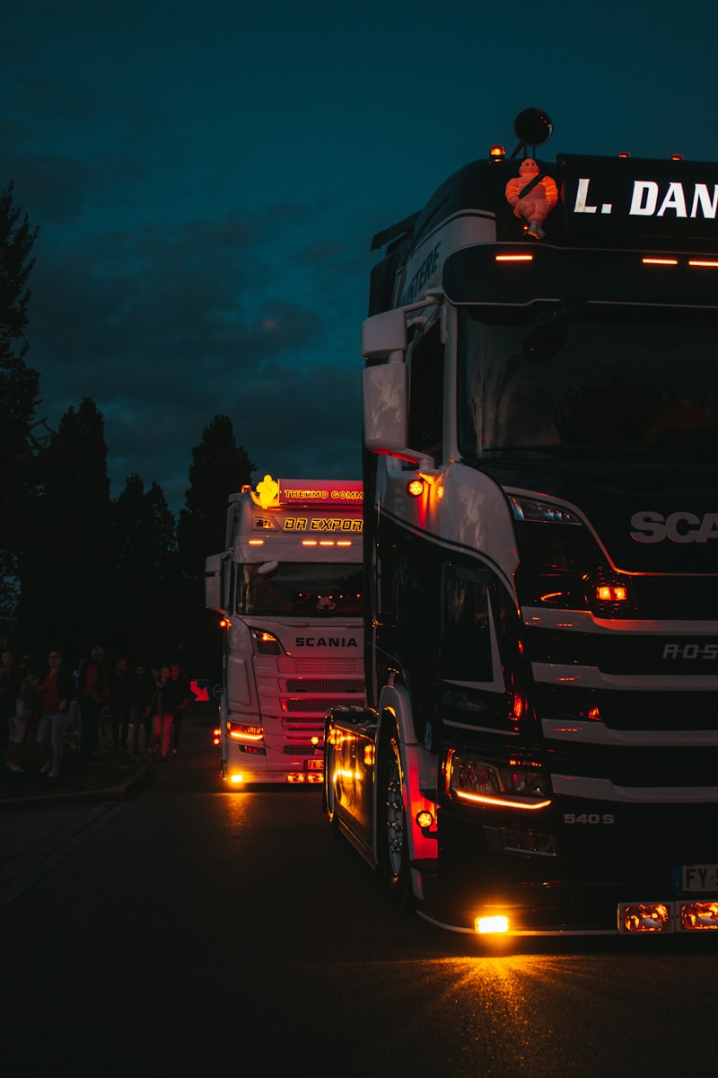 a group of trucks on a street at night a group of trucks on a street at night